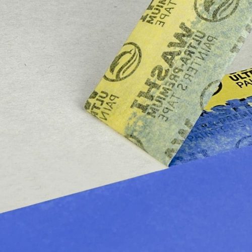 Použitie Blue Dolphin maskovacej pásky počas práce – čisté maliarske hrany a presné vedenie pásky na stene